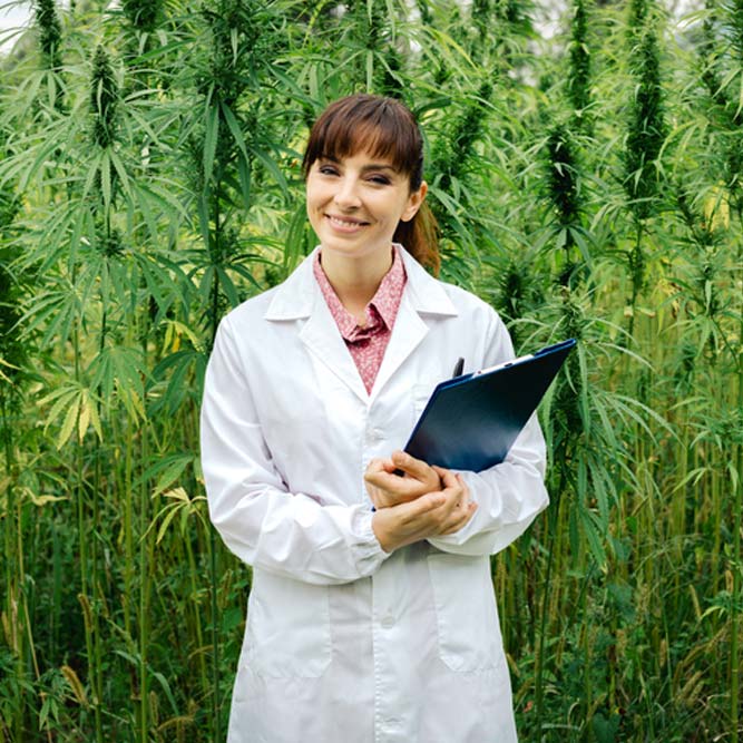 female doctor with clipboard posing in a hemp field